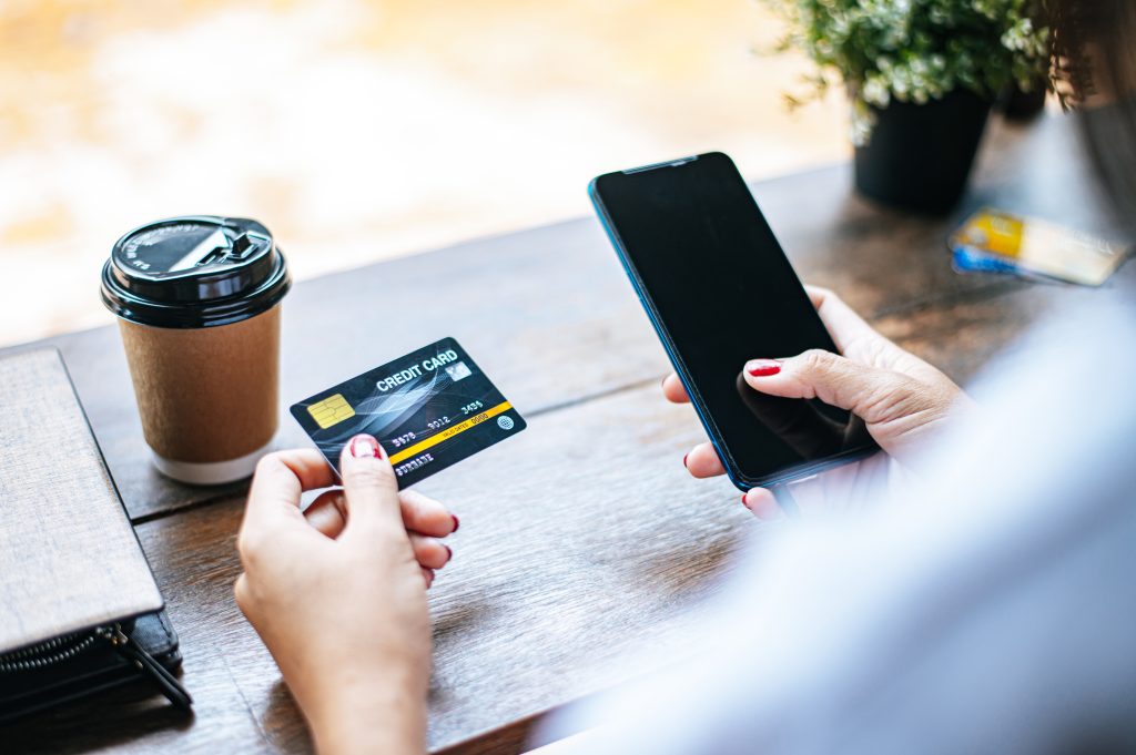 Une personne utilise une carte bancaire et un téléphone.