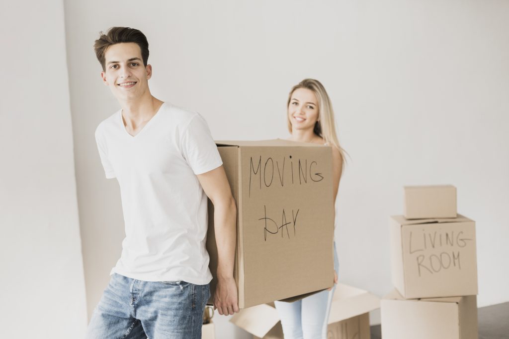 Un couple porte un carton lors de son déménagement.