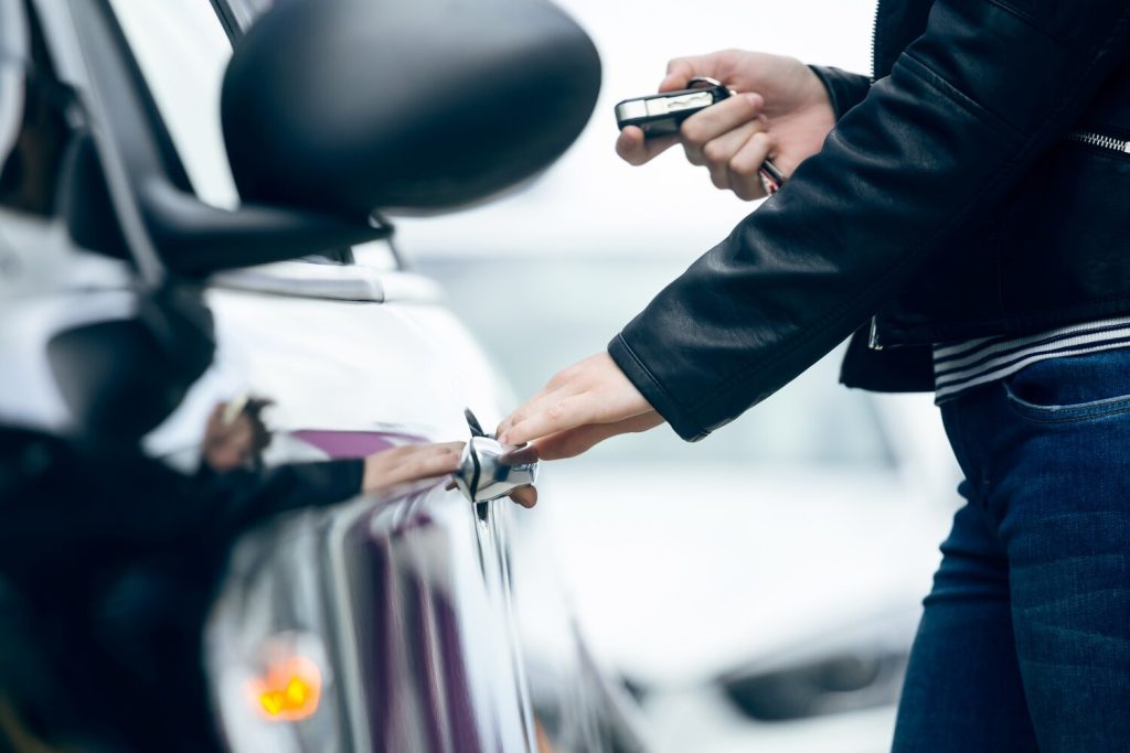 beautiful young woman opening her car.