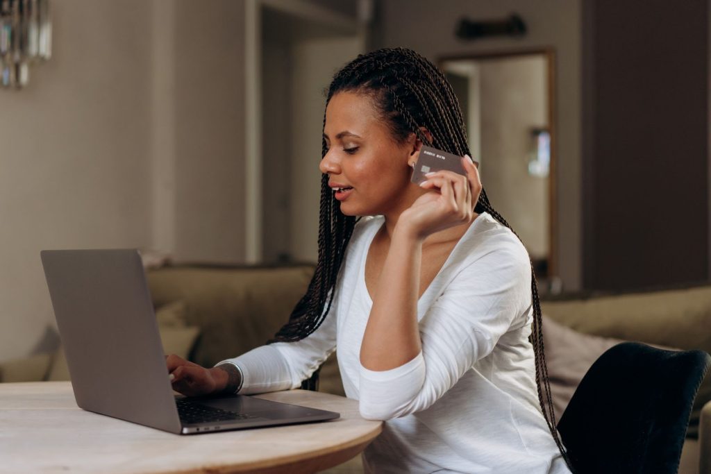 Une femme utilise un ordinateur portable avec une carte bancaire.